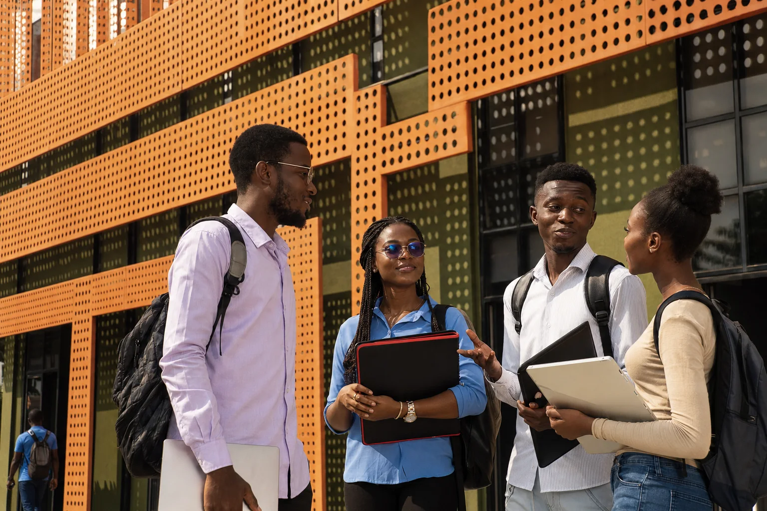 Étudiants devant la façade au claustra de béton ajouré orange de l'Institut