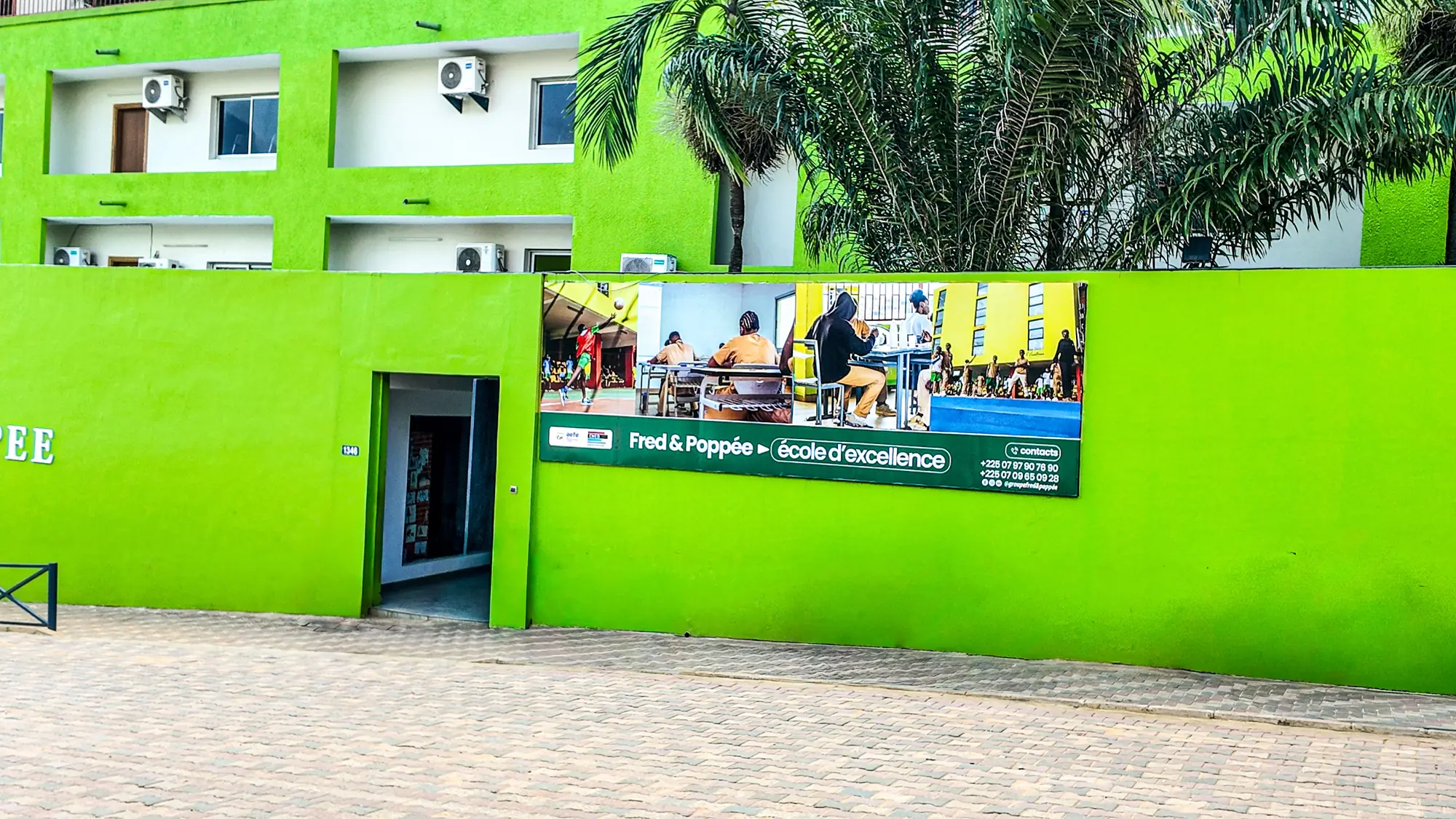 Mur de clôture vert du Lycée Français et bâche « école d'excellence »