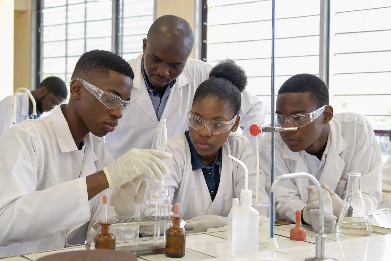 Lycéens en travaux pratiques de sciences, lunettes de protection et verrerie